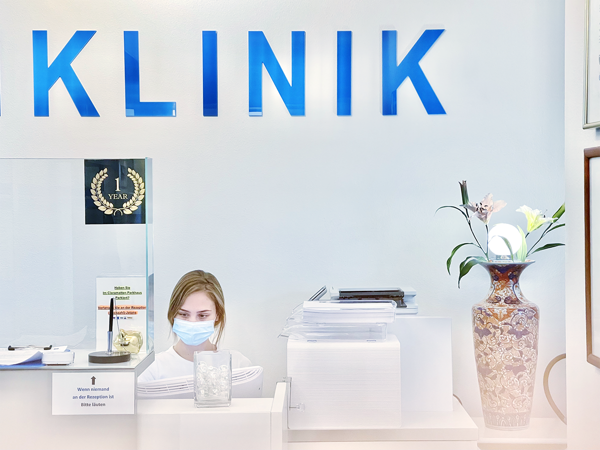 Empfangsbereich der ACC Zahnklinik Basel, Nahaufnahme mit moderner Rezeption