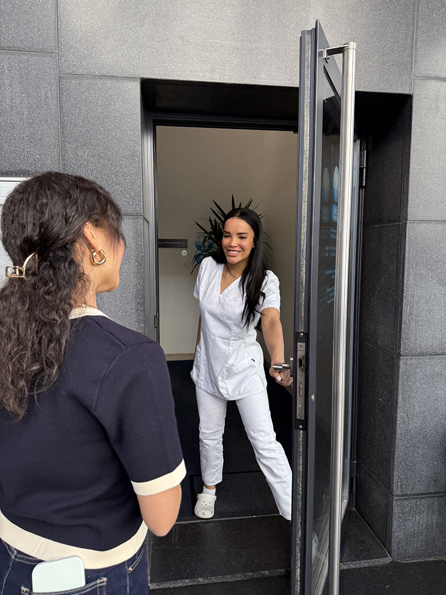 Patientin wird herzlich an der Eingangstür der ACC Zahnklinik Basel empfangen – Ein typischer Praxisbesuch im Überblick