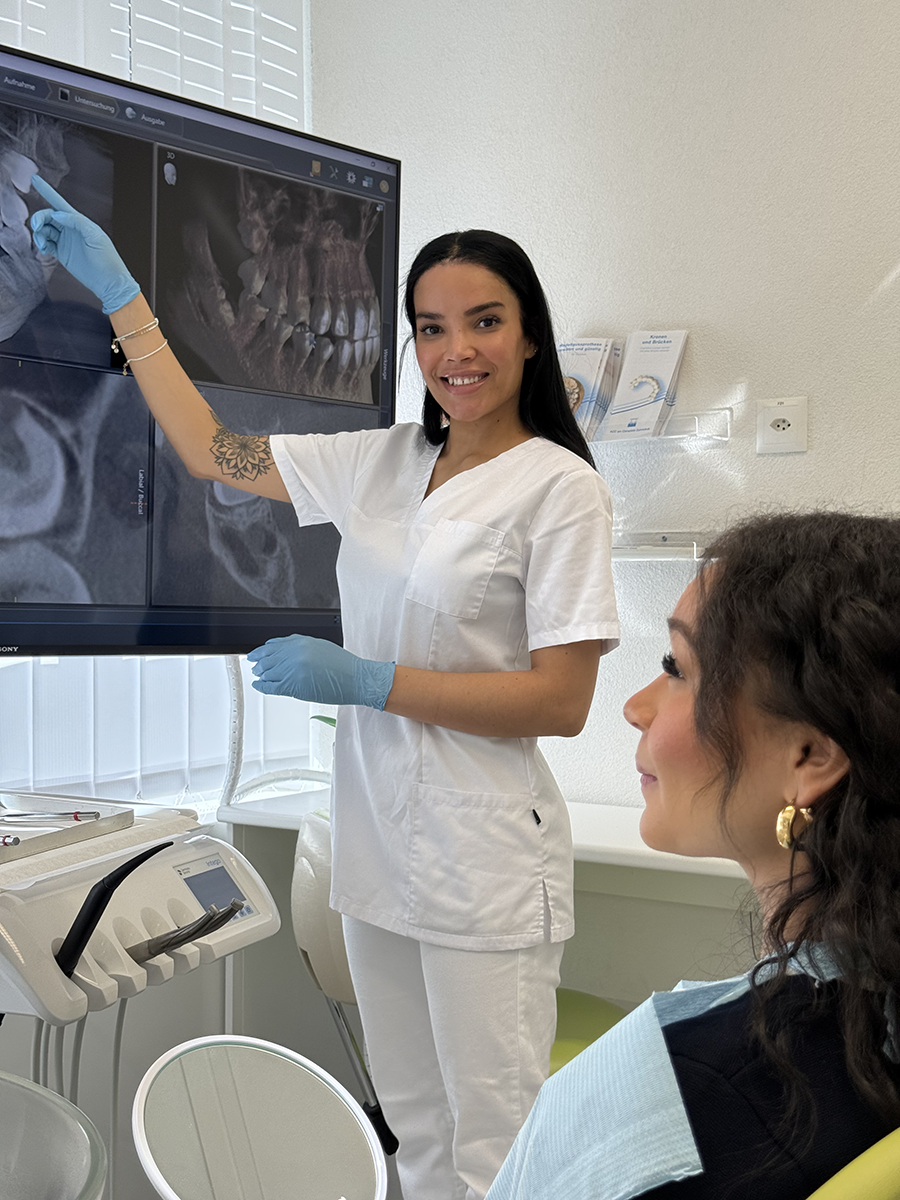 Praxisassistentin erklärt Patientin die Behandlung anhand der Röntgenbilder – Transparenz bei der ACC Zahnklinik Basel