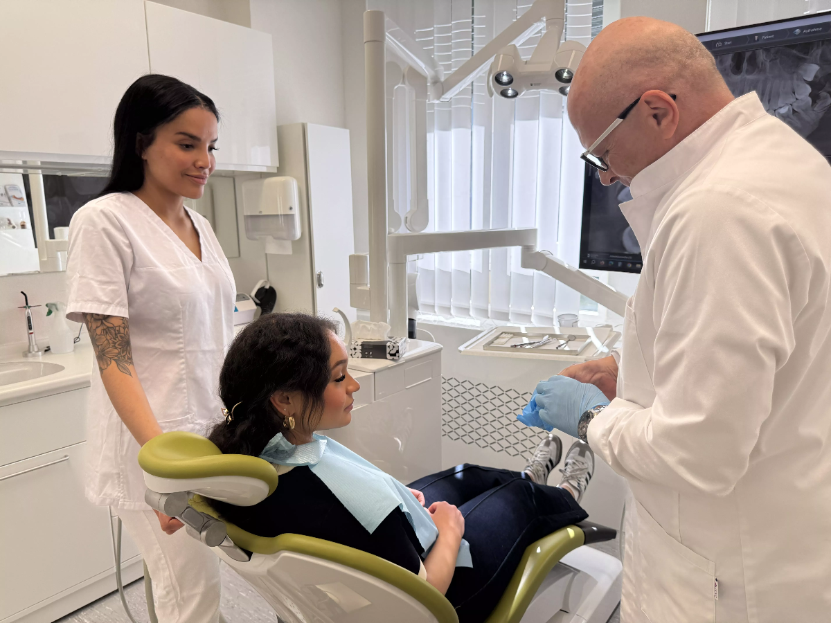 Oberarzt kontrolliert Behandlung und erklärt der Patientin das weitere Vorgehen – Qualität und Fürsorge in der ACC Zahnklinik Basel